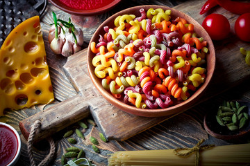Raw pasta in the composition on the table with items for cooking