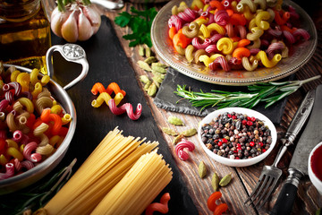 Raw pasta in the composition on the table with items for cooking