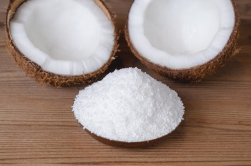 coconut flakes in a bowl on wooden background