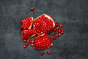 Fototapeta na wymiar Pomegranate and seeds close-up on dark concrete background