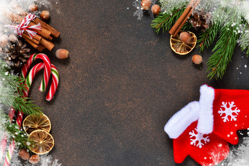 Christmas tree with decorations and mittens on a brown background with space under the text.