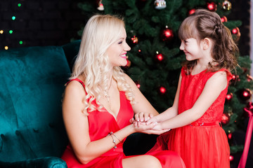 Closeup portrait of beautiful young family. Blond mother and little daughter posing in holiday home...