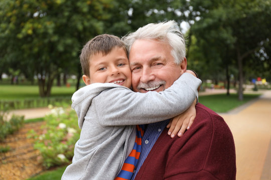 Happy senior man with grandson in park
