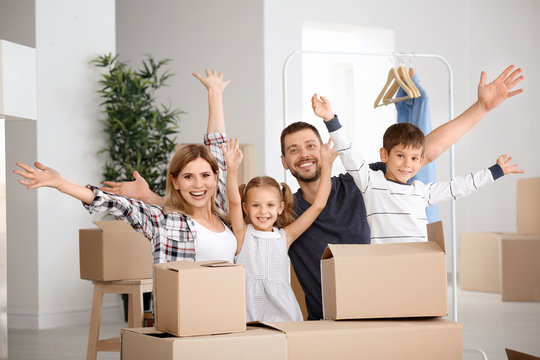 Happy family with cardboard boxes in new flat