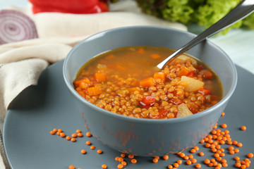 Dish with tasty lentil soup on table