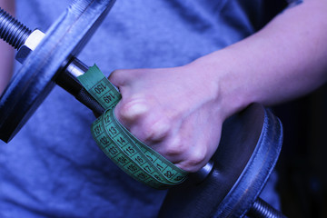 A girl holds a centimeter in his hands. The concept of weight loss. Struggle with weight.