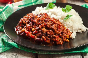 Hot chili con carne with ground beef, beans, tomatoes and corn served with rice