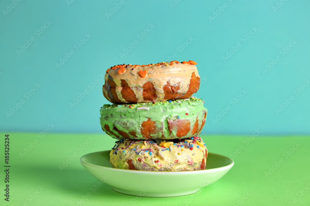 Sticker Plate with tasty donuts on color background