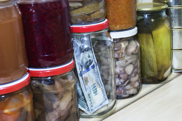 dollar in a glass jar on the background of canned