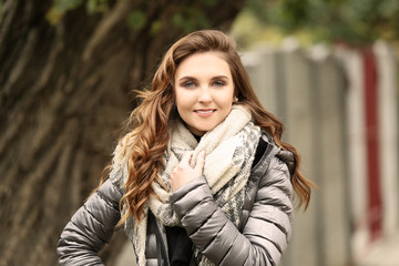 Beautiful smiling woman in puffer jacket outdoors