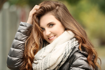 Beautiful smiling woman in puffer jacket outdoors