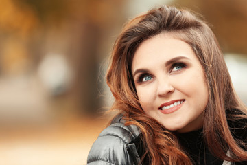 Beautiful smiling woman in puffer jacket outdoors
