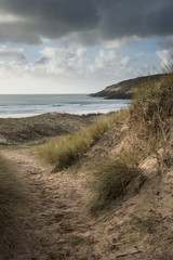 Fototapeta na wymiar Beautiful landscape image of Freshwater West beach with sand dunes on Pembrokeshire Coast in Wales