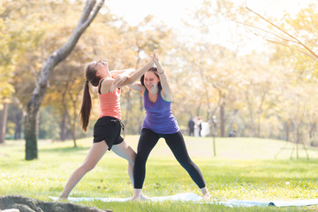 Holiday my Sisters
 doing yoga pose meditation in the public park Sport Healthy concept.