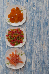 Vertical frame, candied dried apricots, papaya, pineapple on a blue wooden table, top view