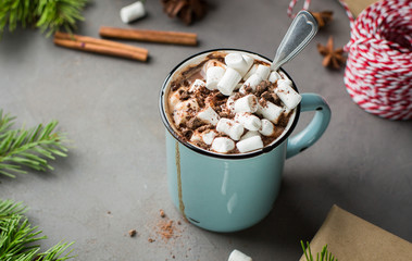 Mug of hot chocolate with marshmallow and cinnamon on a gray concrete background with a Christmas...