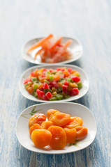 Different candied fruits in plates on a wooden table