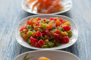 Candied pineapple in a white dish on a wooden background
