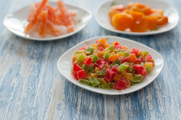 Candied pineapple cubes in a white dish on a wooden table