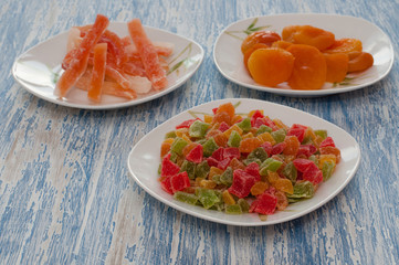 Candied pineapple cubes in a white dish on a wooden table