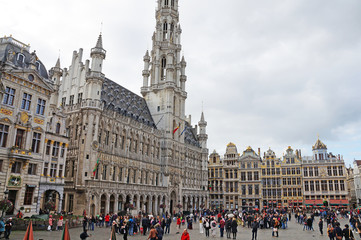 Naklejka premium Grand Place in Brussels. Many tourists walk and look at beautiful buildings on the main square in Brussels.