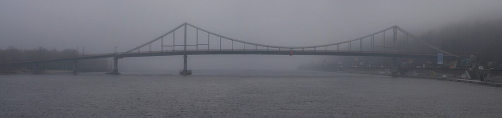 KYIV, UKRAINE- DECEMBER 09,2017: Beautiful foggy morning cityscape. Pedestrian bridge to the Trukhanov island in rich fog, mist background. Winter morning view