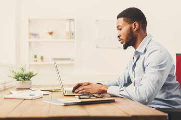 Young black businessman working with laptop