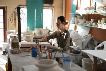 Female potter working at worktop