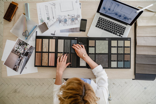 Overhead photo of woman interior designer working with material palette at her office.