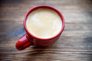 coffee in a red mug on an old wooden background