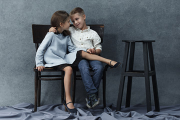 A portrait of little girl and a boy on the gray background