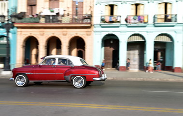 Fototapeta na wymiar Panning shot of American vintage car travelling in Paseo de Marti, Old Havana, Cuba