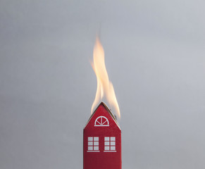 House fire concept. Toy house with flames