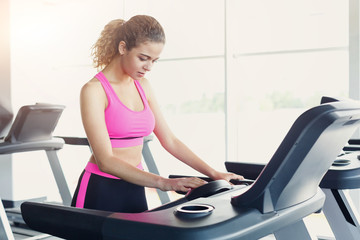 Attractive woman on treadmill in fitness club, healthy lifestyle