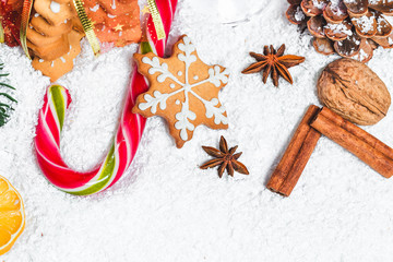 Christmas background with gingerbread cookie, snow and branches of a Christmas tree.