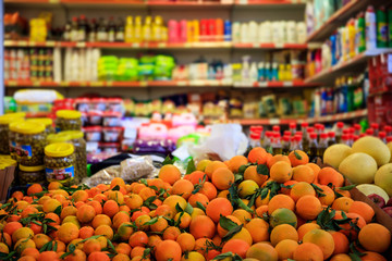 Citrus fruits in row. Blurred products in market store. Close up view. - obrazy, fototapety, plakaty