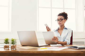 Serious business woman reading document at office desktop