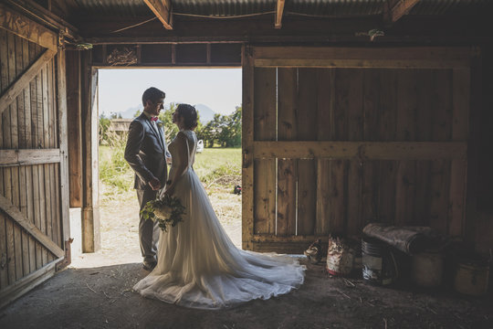 Side view of couple looking each other while standing in barn