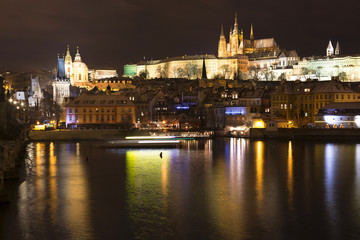 Fototapeta na wymiar Christmas night snowy Prague Lesser Town with Charles Bridge and Prague Castle, Czech republic