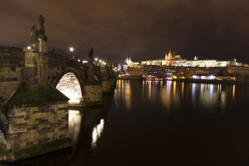 Fototapeta premium Christmas night snowy Prague Lesser Town with Charles Bridge and Prague Castle, Czech republic