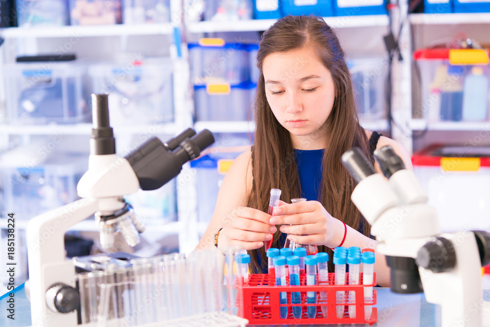 Poster a teenage girl in a school laboratory in chemistry and biology classes