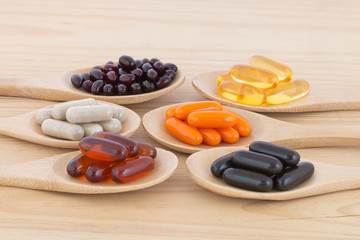 Healthy Vitamin supplement capsules in a spoons.