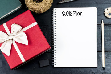 2018 Plan text on notebook paper with gift box for business concept.