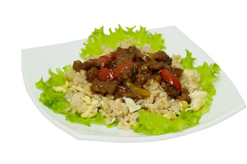 Asian food - roast meat with vegetables and rice  on a white plate.