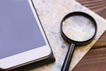 Mobile phone, map and magnifying glass
