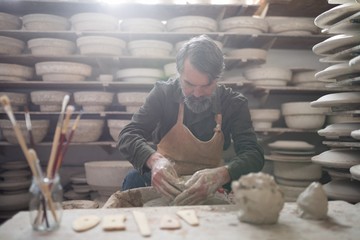 Male potter molding a clay