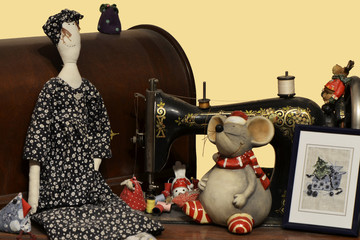 Antique sewing machine festive decorated with doll, mouse, embroidered picture and small figures...