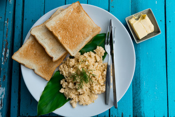 breakfast (Scrambled eggs and bread) with wood  background