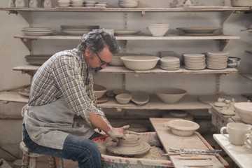 Male potter molding a clay