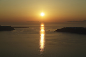 Sunset on Santorini island with some sailboats, Greece